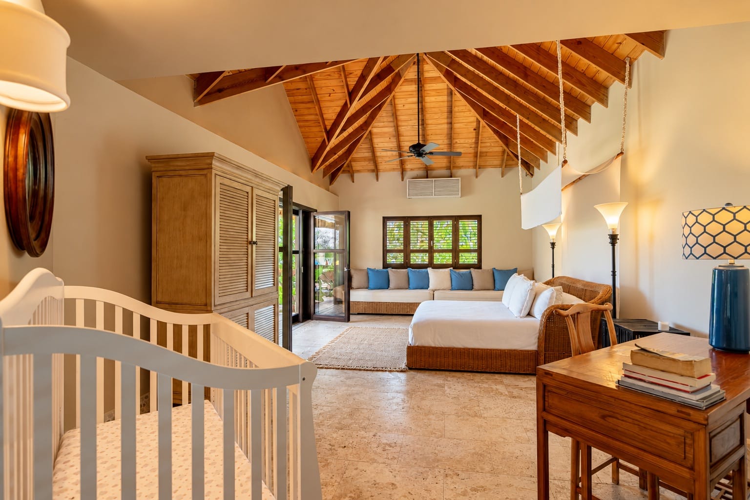 Second master suite with king bed and daybed under a wooden ceiling