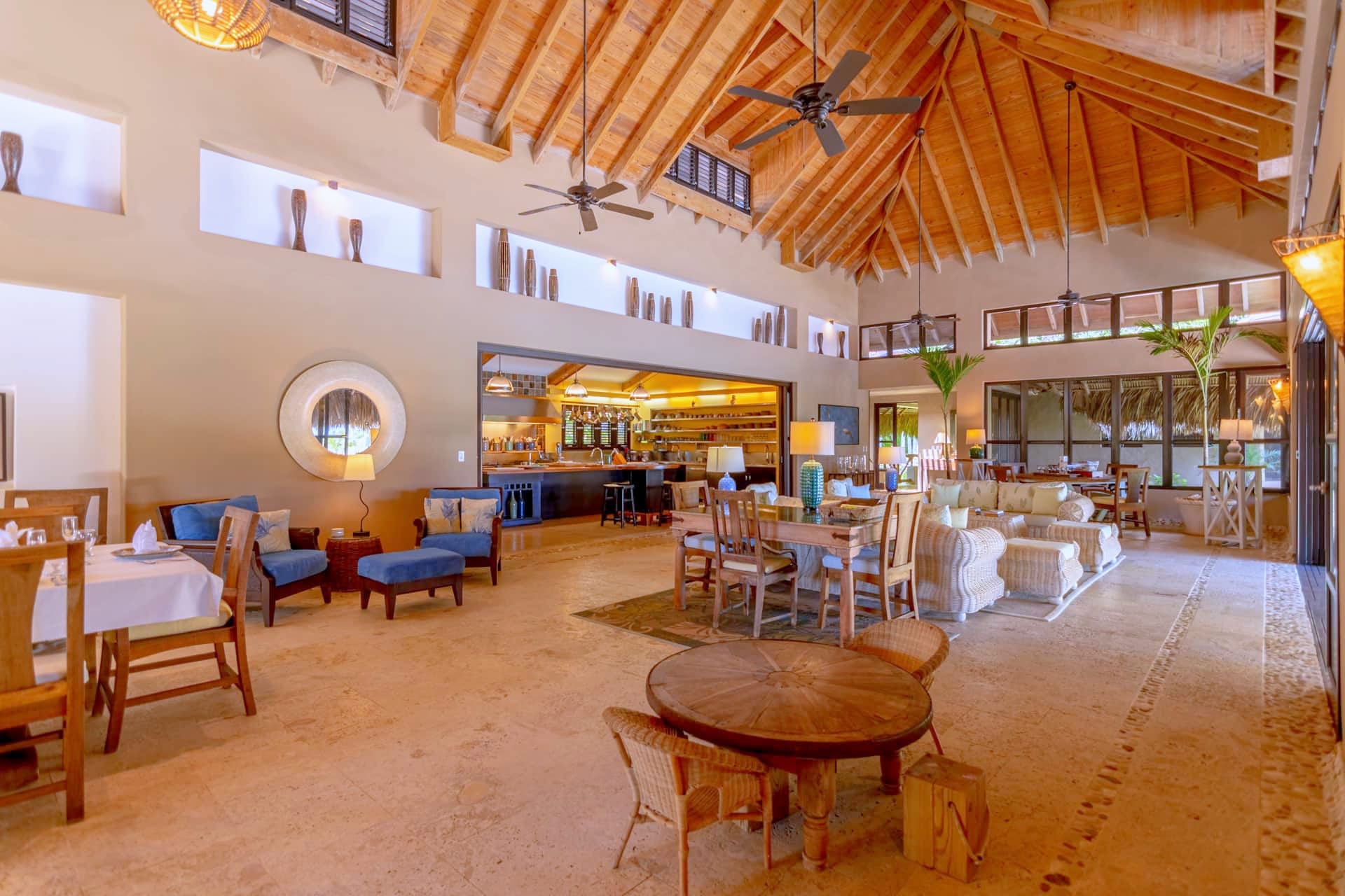 Open living and dining area under a cathedral ceiling with exposed wooden beams