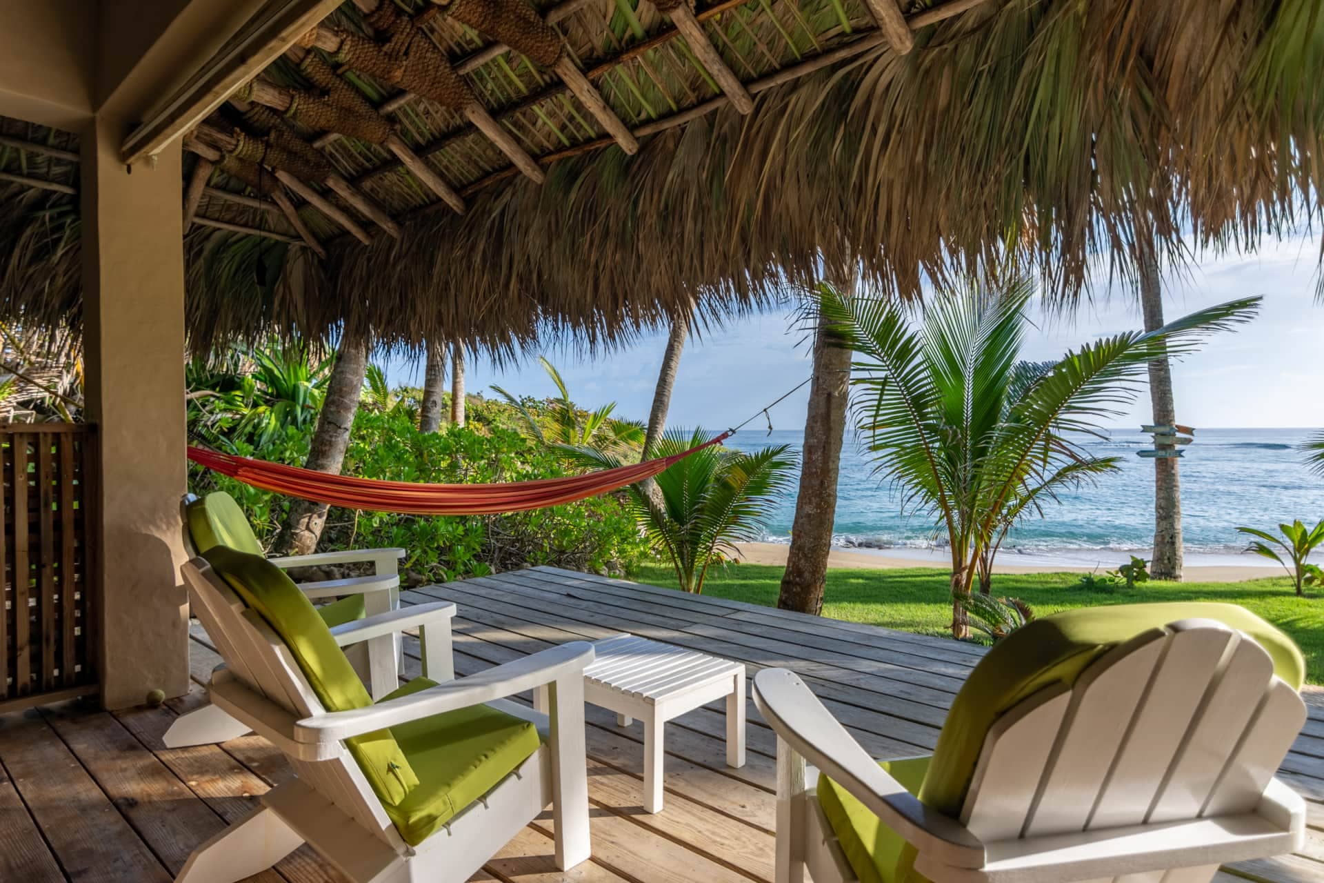 Beachfront deck with hammock and lounge chairs facing the ocean