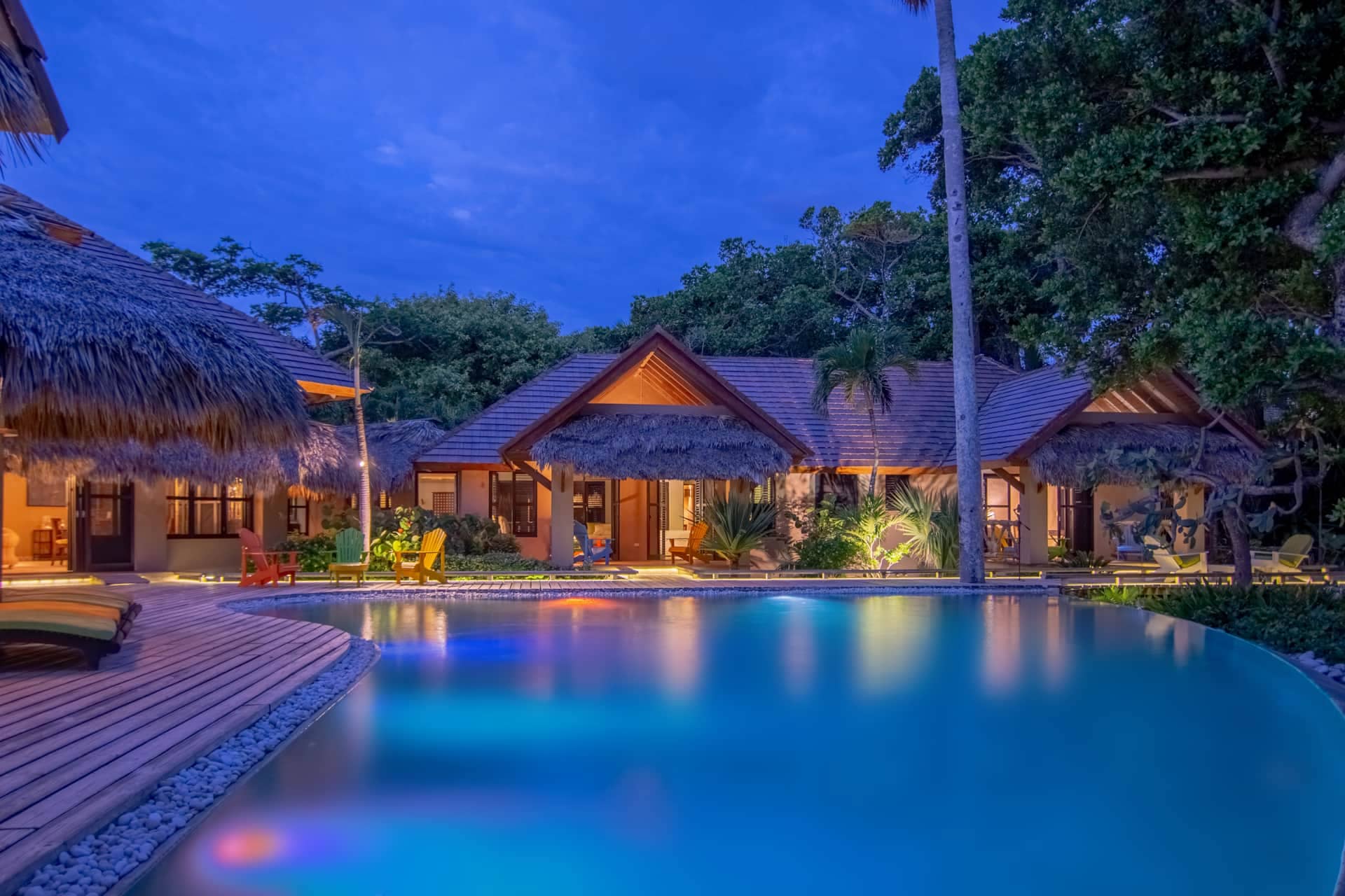 Pool and villa lit up at dusk