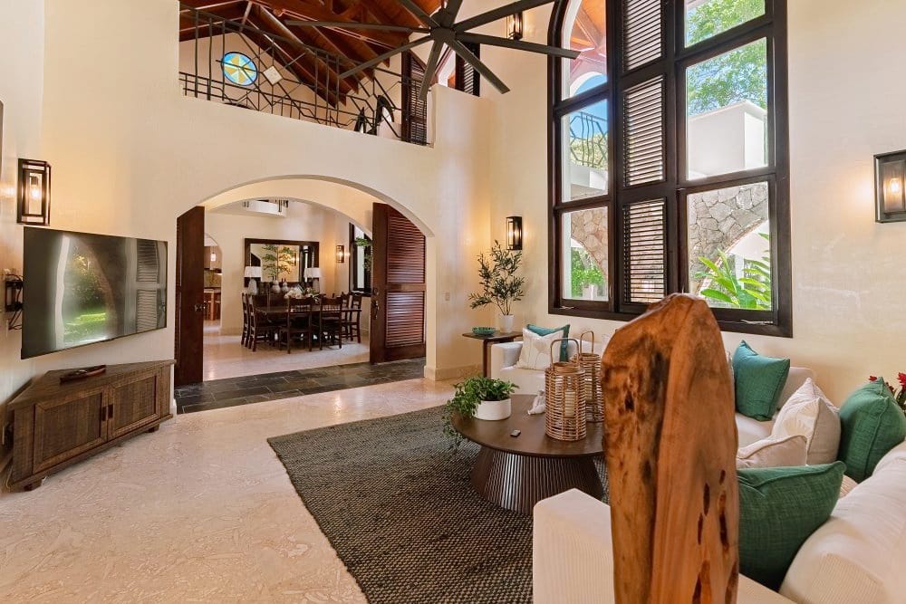 Living room with wooden ceiling and arched doorway to the dining room