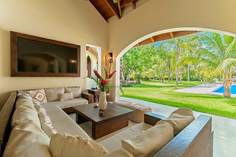 Outdoor lounge with sofas facing the pool and garden