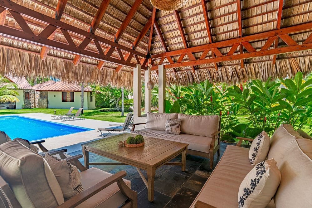 Thatched gazebo with lounge area next to the pool