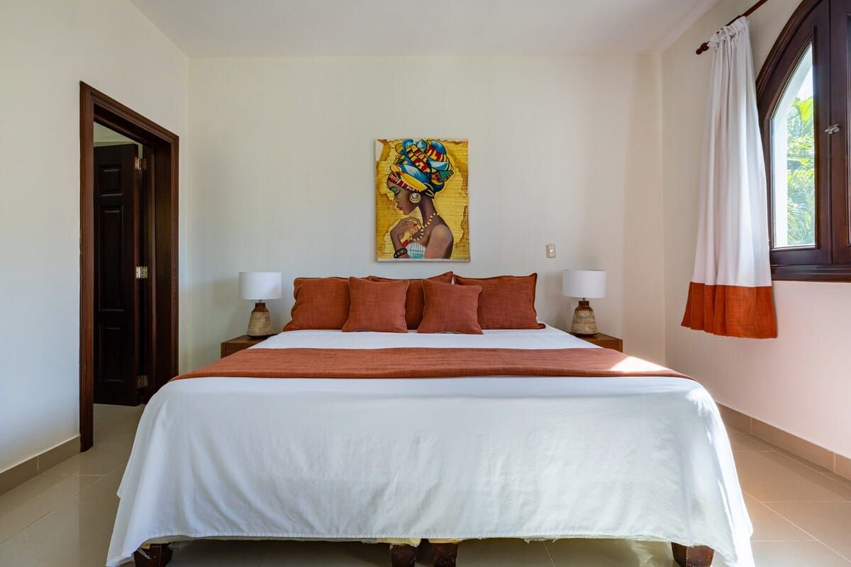 Bright bedroom with king bed and local artwork
