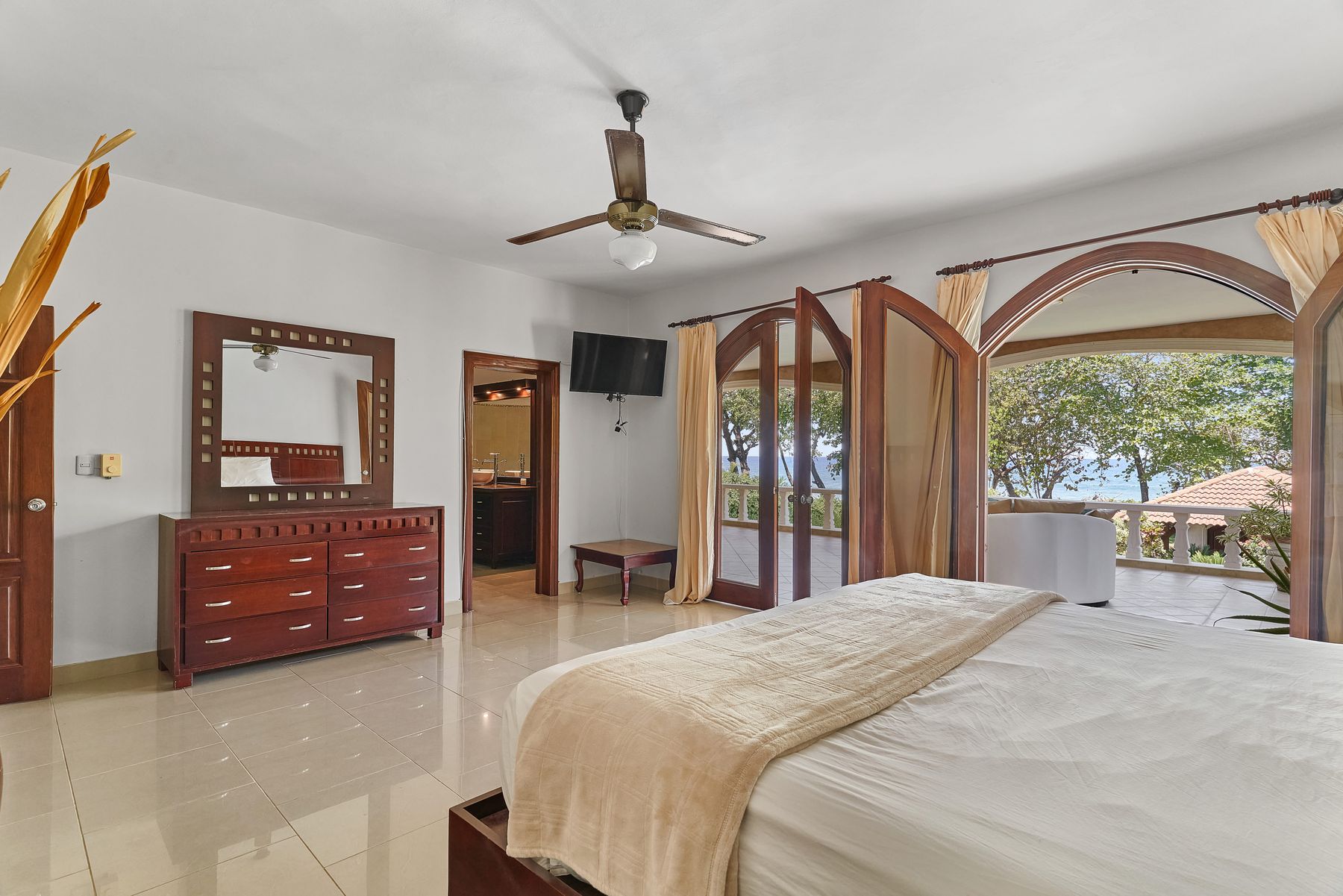 Master bedroom with doors opening onto an ocean-view terrace
