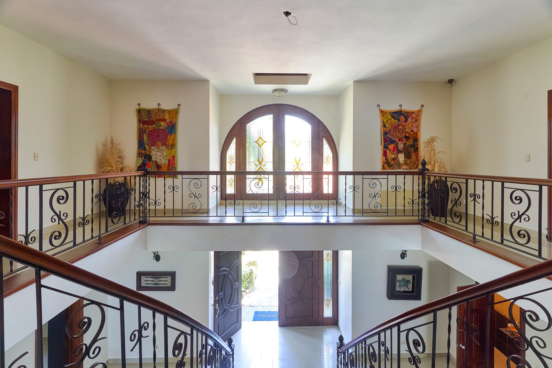 Double-height entrance hall with wrought-iron staircase
