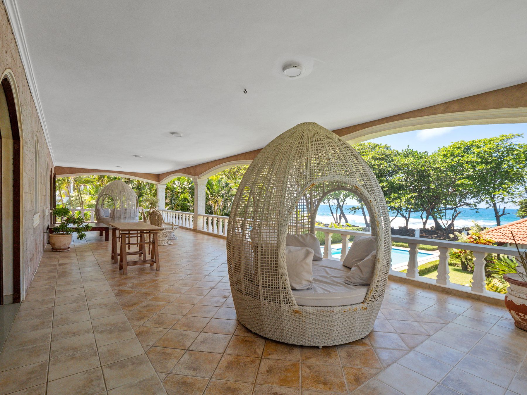 Covered terrace with ocean view and hanging lounge chair